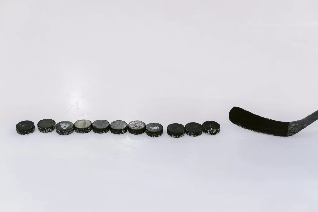 11 Hockey Pucks aligned vertically on icefloor