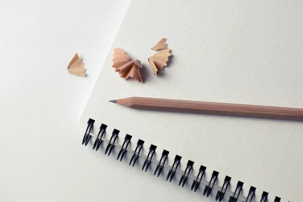 Wooden Pencil on White Notepad